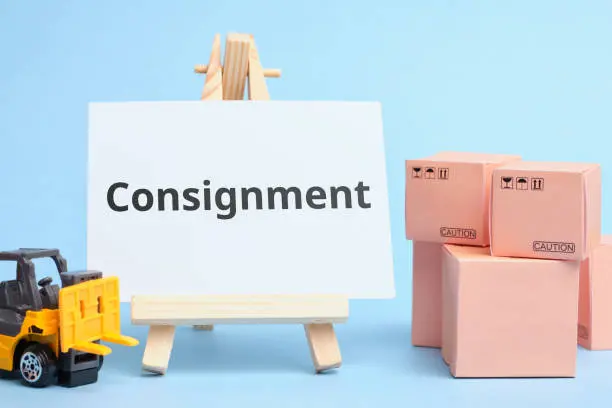 A sign that says consignment next to boxes.