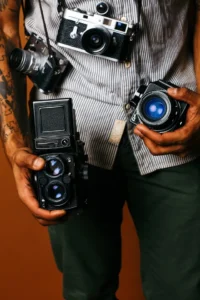 A man holding two cameras in his hands.